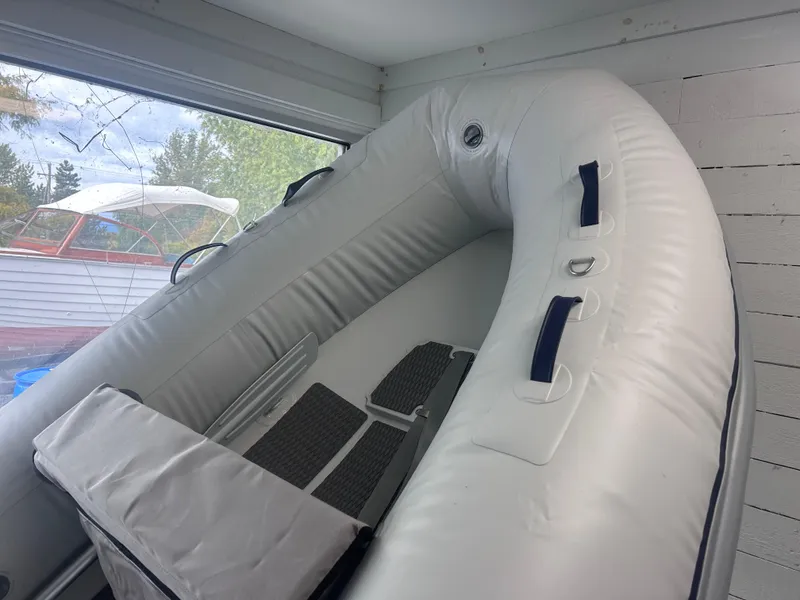 Slide: The Image of 2024 Highfield Ultralite 310 inflatable boat in storage, white interior, wooden floor. - 4