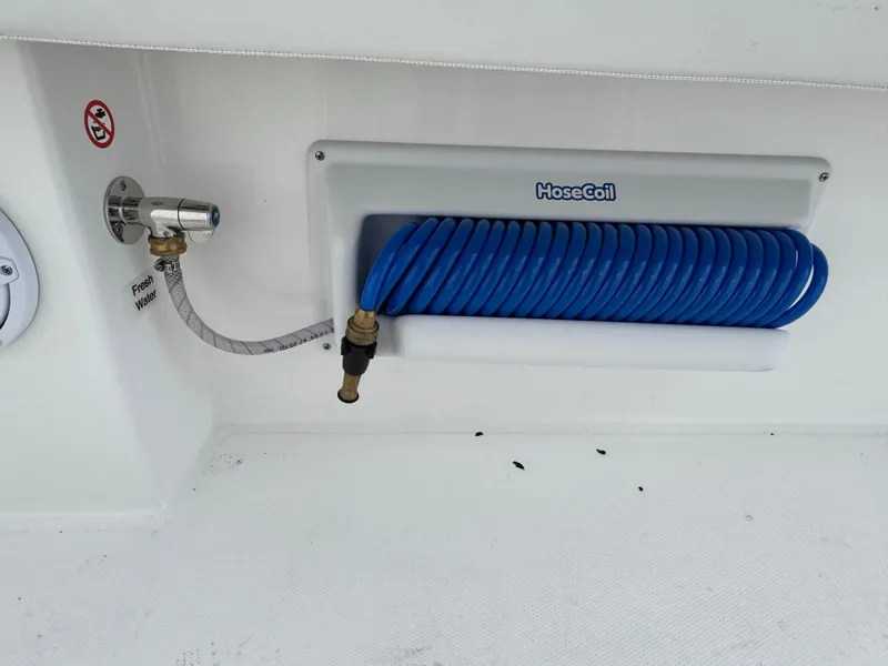 Slide: The Image of Coiled blue hose on 2025 Regulator 31 boat, with faucet and HoseCoil branding. - 14