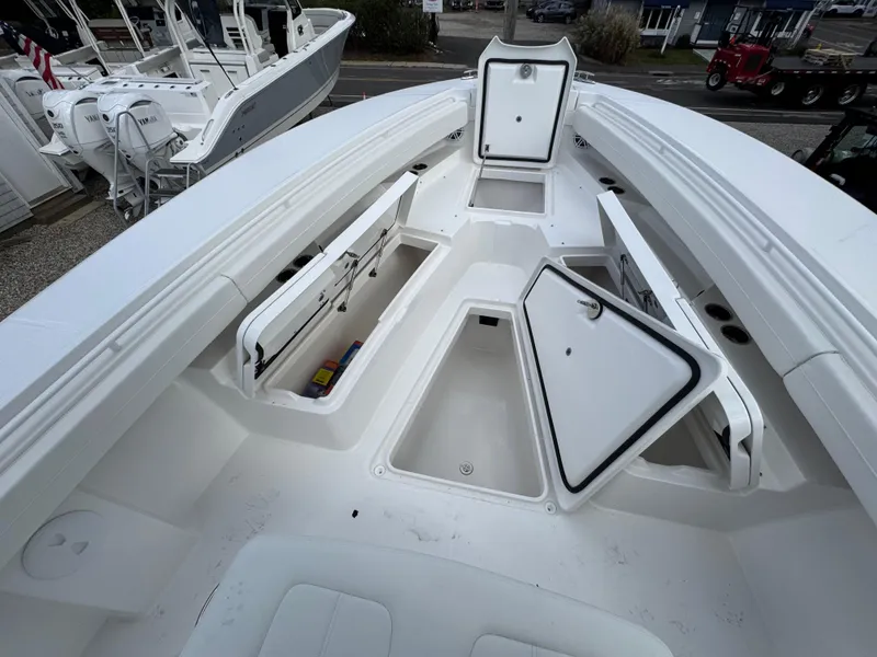 Slide: The Image of 2025 Regulator 31 boat with open storage compartments and sleek white design. - 16