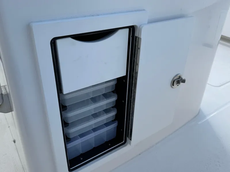 Slide: The Image of 2025 Regulator 31 boat storage compartment with organized tackle boxes. - 22