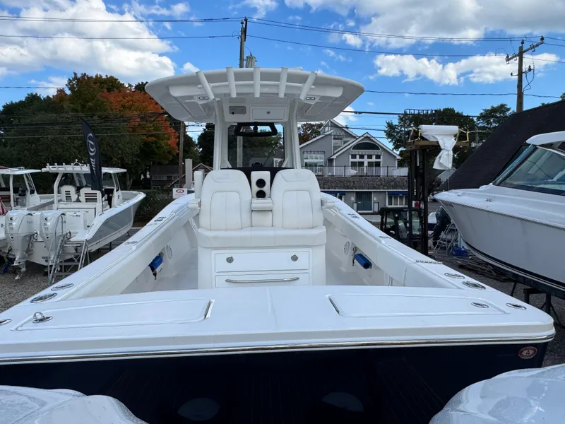 Slide: The Image of 2025 Regulator 31 boat with T-top, docked under a partly cloudy sky. - 4