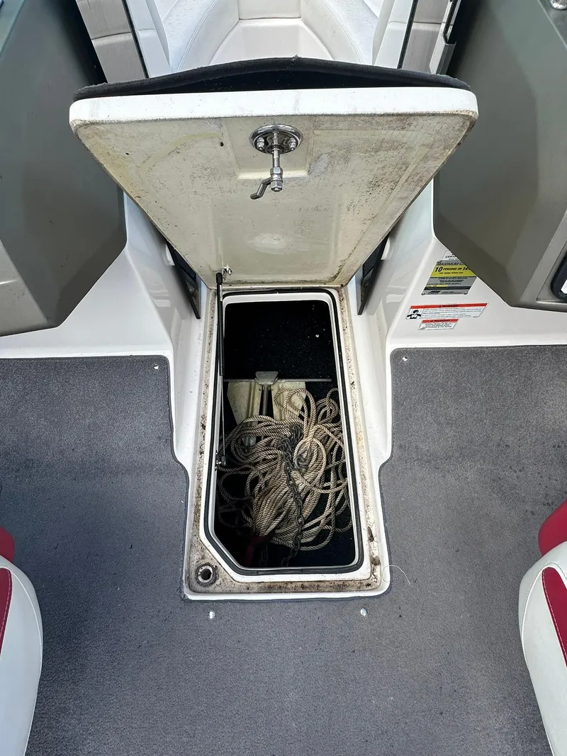 Slide: The Image of Open storage compartment on 2011 Regal 2100 Bowrider boat with rope inside. - 10
