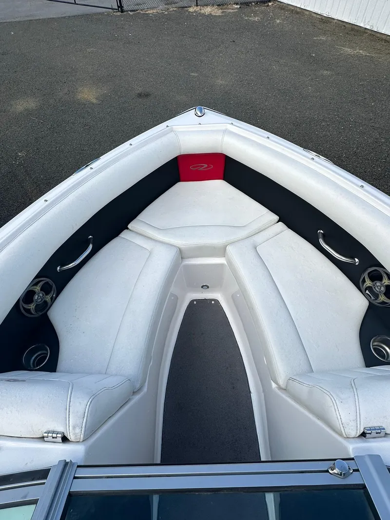 Slide: The Image of 2011 Regal 2100 Bowrider boat interior with white seating and cup holders. - 13