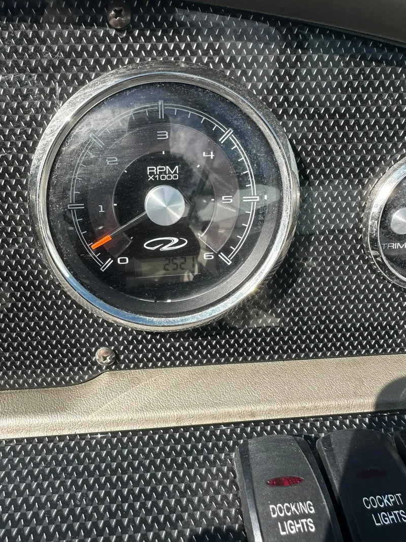 Slide: The Image of Close-up of 2011 Regal 2100 Bowrider dashboard with RPM gauge and light switches. - 17
