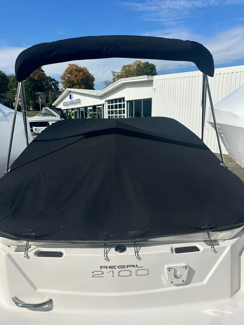 Slide: The Image of 2011 Regal 2100 Bowrider with black cover, parked outdoors. - 18