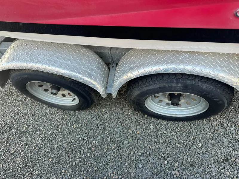 Slide: The Image of 2011 Regal 2100 Bowrider trailer wheels on gravel surface. - 22