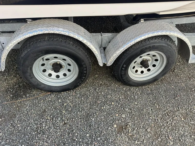 Slide: The Image of Trailer wheels for 2011 Regal 2100 Bowrider on gravel surface. - 23