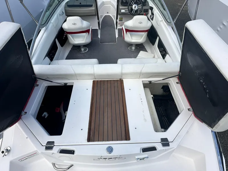 Slide: The Image of 2011 Regal 2100 Bowrider interior with open storage compartments and seating. - 5