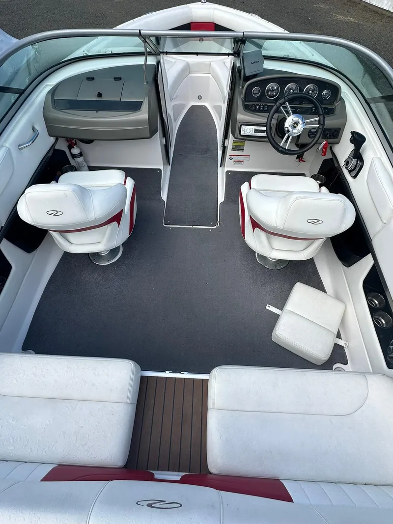 Slide: The Image of 2011 Regal 2100 Bowrider interior with white seating and modern dashboard. - 6
