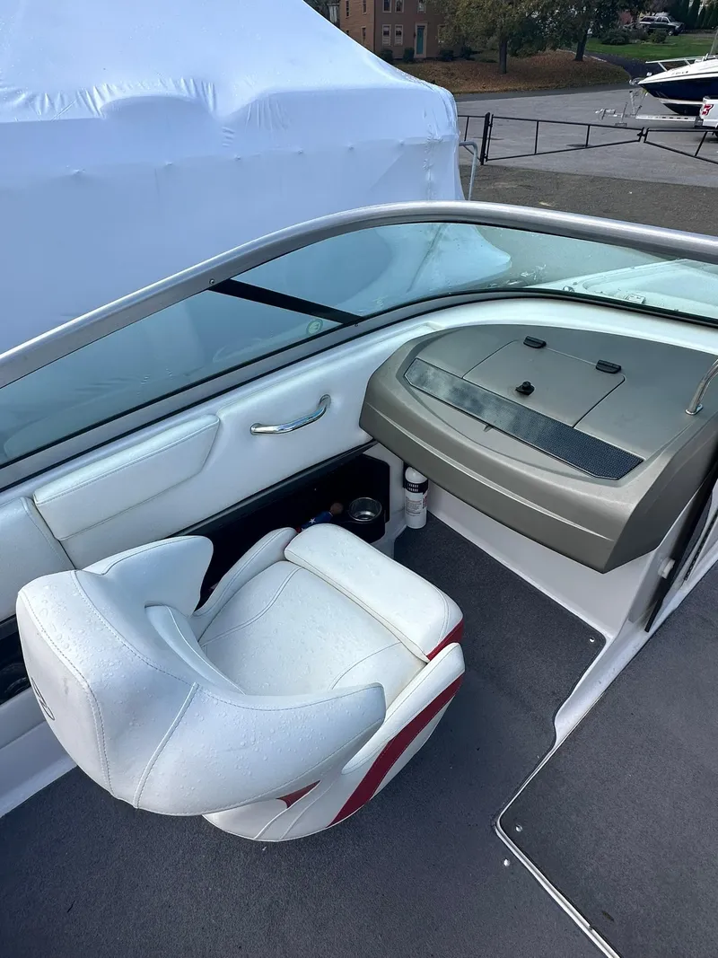 Slide: The Image of 2011 Regal 2100 Bowrider interior with white seating and dashboard view. - 9