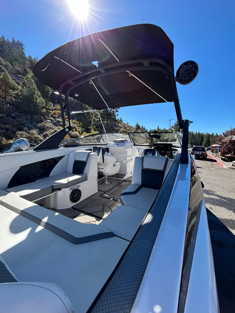 Slide: The Image of 2019 Scarab 255 ID boat with sleek design, spacious seating, and modern features under a clear blue sky. - 14