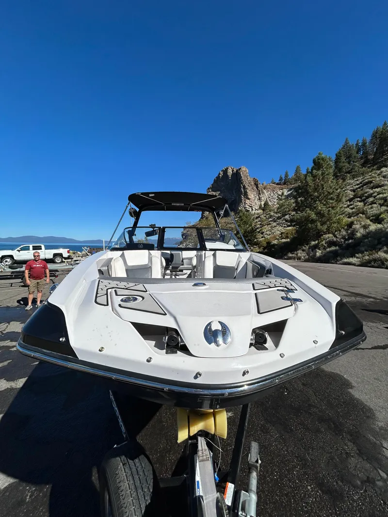 Slide: The Image of 2019 Scarab 255 ID boat on trailer, parked near scenic mountain landscape. - 15