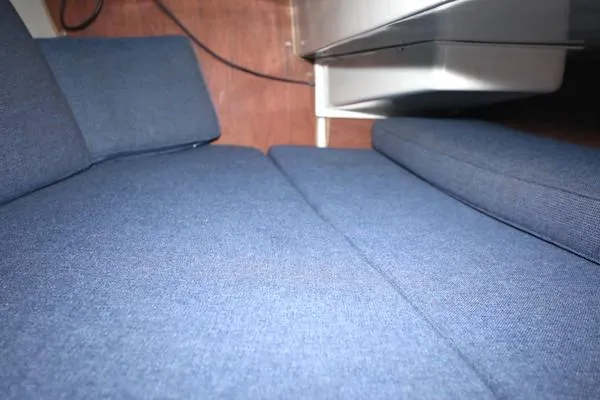 Slide: The Image of Interior of 1983 Catalina 30 sailboat with blue cushions and wooden paneling. - 13