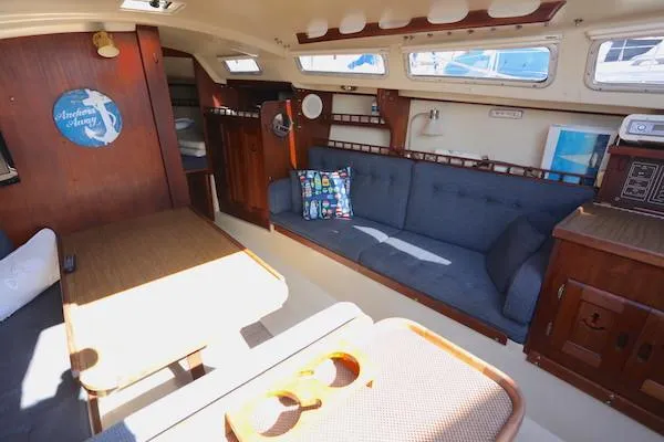 Slide: The Image of Interior of a 1983 Catalina 30 sailboat with cozy seating and wooden accents. - 4