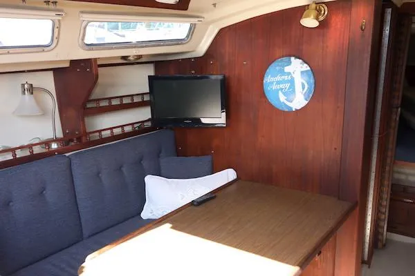 Slide: The Image of Interior of 1983 Catalina 30 sailboat with cozy seating and wall-mounted TV. - 9