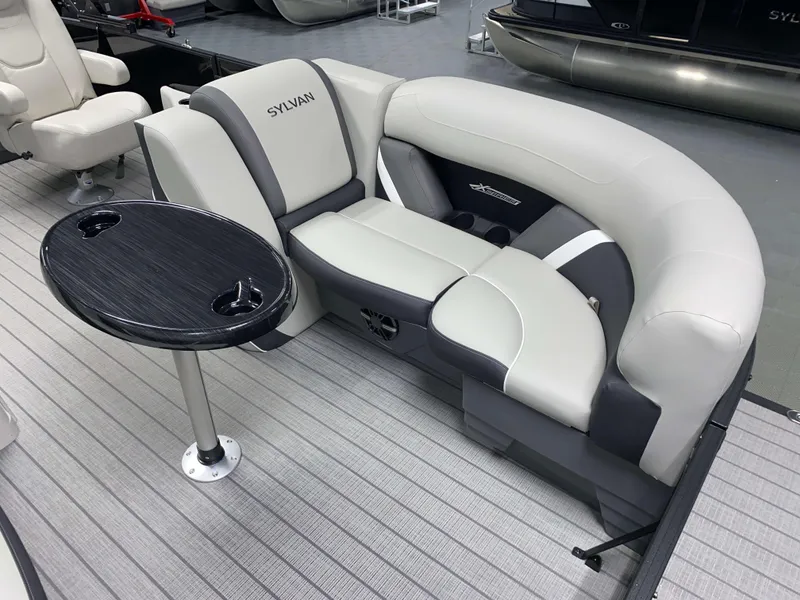 Slide: The Image of 2025 Sylvan Mirage X3 CLZ DH Tritoon interior with plush seating and table. - 12