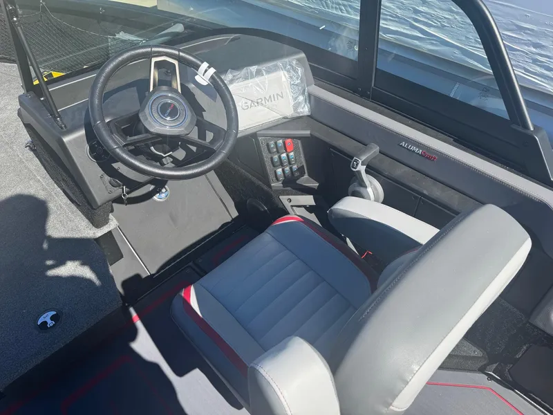 Slide: The Image of 2025 Alumacraft Trophy 185X SC Rotax S boat interior with steering wheel and Garmin system. - 20