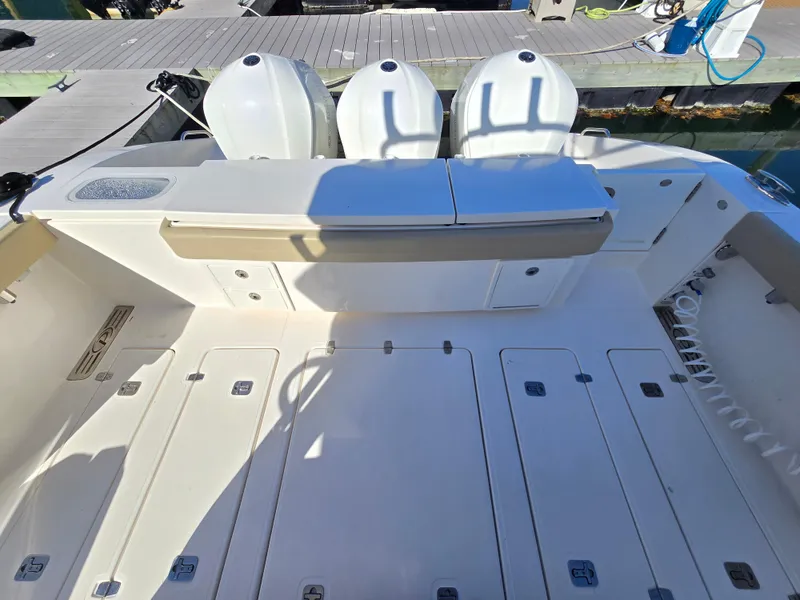 Slide: The Image of 2018 Pursuit S 408 Sport boat deck with triple outboard engines. - 10