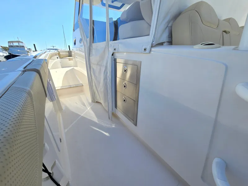 Slide: The Image of 2018 Pursuit S 408 Sport boat interior with seating and storage drawers. - 13