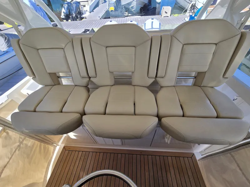 Slide: The Image of 2018 Pursuit S 408 Sport boat with beige leather seating and wooden deck. - 15