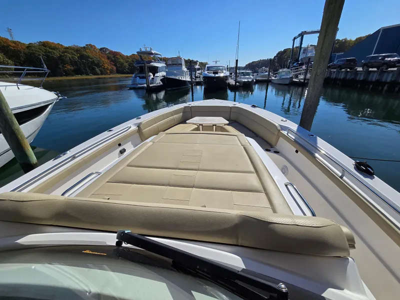 Slide: The Image of 2018 Pursuit S 408 Sport boat docked in a marina, featuring spacious deck seating. - 33