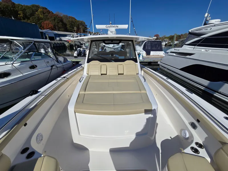 Slide: The Image of 2018 Pursuit S 408 Sport boat with beige seating, docked among other boats. - 34