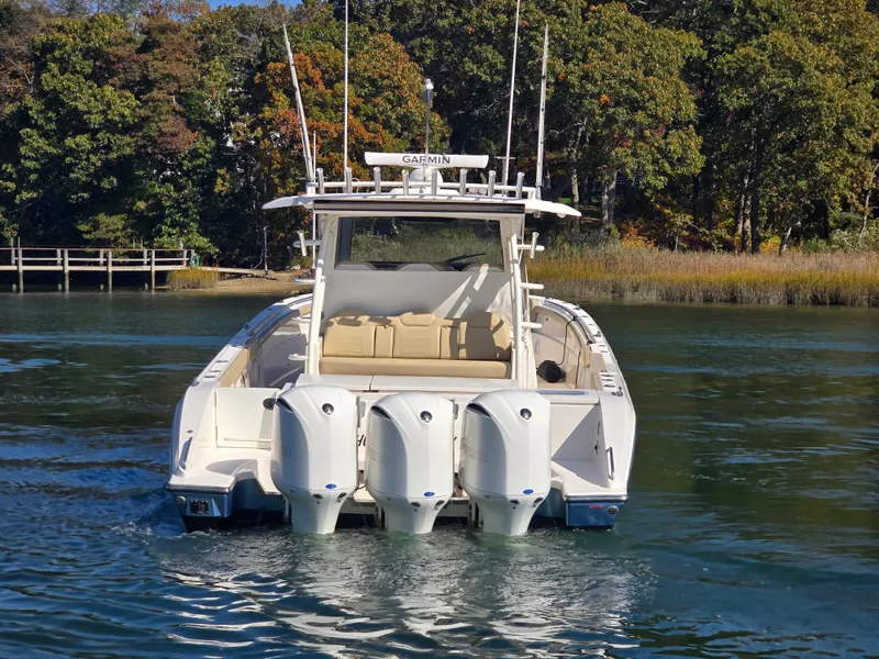Slide: The Image of 2018 Pursuit S 408 Sport boat with four engines on a calm lake. - 4