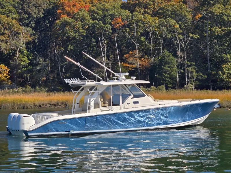 Slide: The Image of 2018 Pursuit S 408 Sport boat on calm water with autumn trees in background. - 5