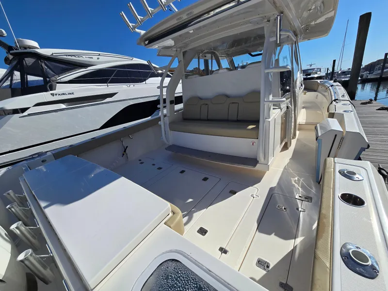 Slide: The Image of 2018 Pursuit S 408 Sport boat with spacious deck and seating, docked at marina. - 9