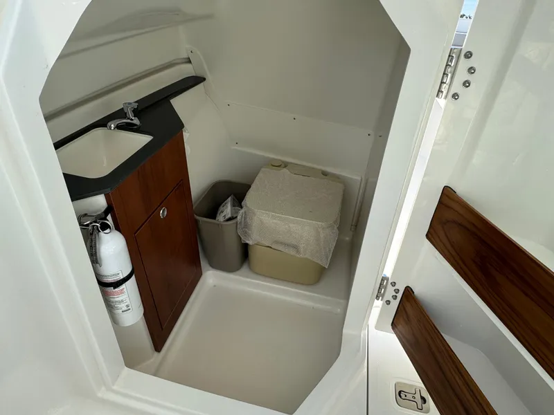 Slide: The Image of 2025 Pursuit DC 246 Dual Console interior with sink, storage, and fire extinguisher. - 10