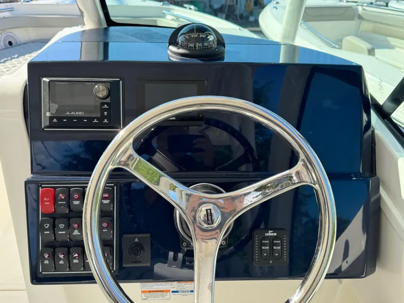 Slide: The Image of Steering console of 2025 Pursuit DC 246 Dual Console boat with navigation controls. - 13