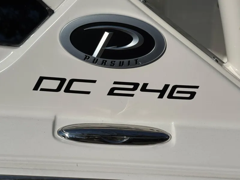 Slide: The Image of 2025 Pursuit DC 246 Dual Console boat logo and model name on white surface. - 15