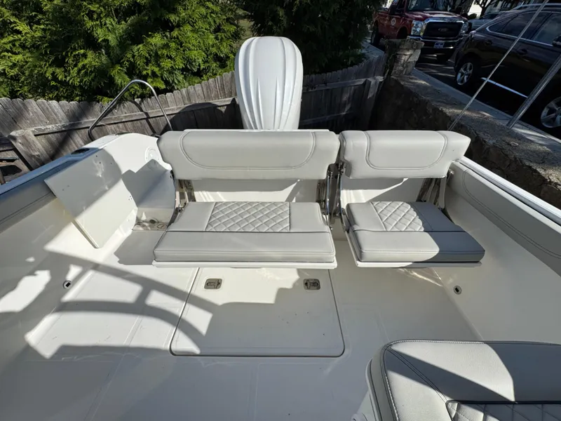 Slide: The Image of 2025 Pursuit DC 246 Dual Console boat interior with white cushioned seating. - 4