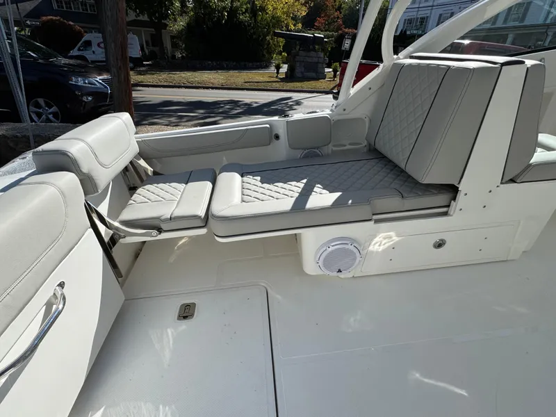 Slide: The Image of 2025 Pursuit DC 246 Dual Console boat interior with cushioned seating and speaker. - 6