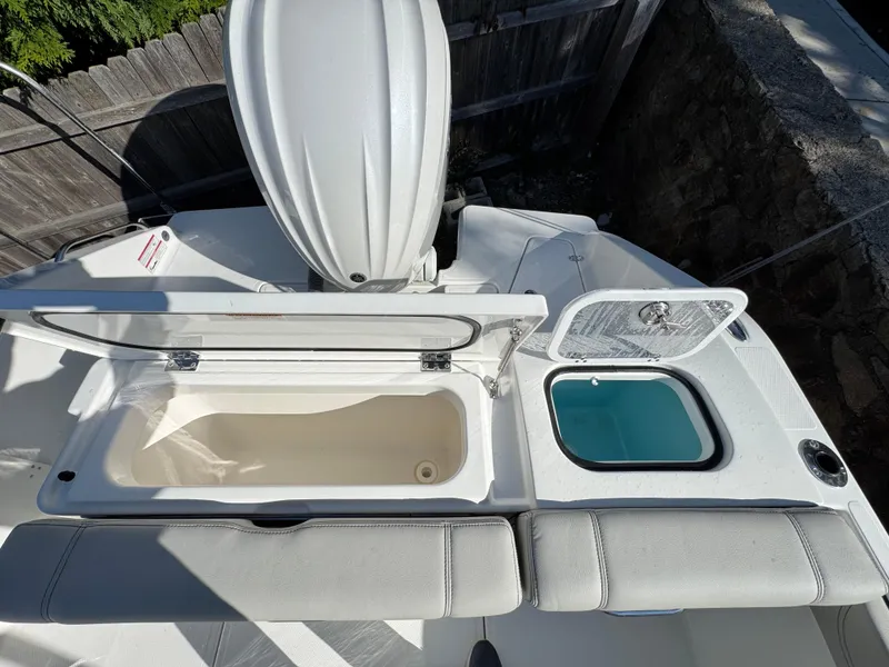 Slide: The Image of 2025 Pursuit DC 246 Dual Console boat with open storage compartments. - 7