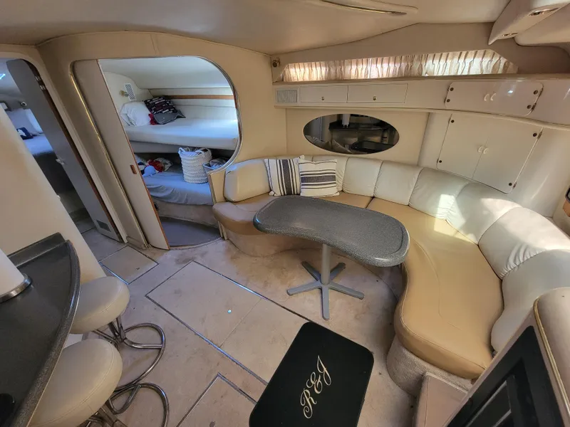 Slide: The Image of Interior of a 1997 Sea Ray 400 Express Cruiser with curved seating and a small table. - 10