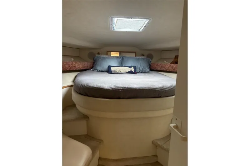 Slide: The Image of 1997 Sea Ray 400 Express Cruiser cabin with cozy bed and nautical decor. - 12
