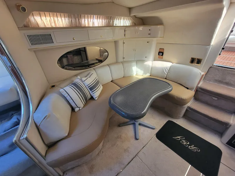 Slide: The Image of Interior of 1997 Sea Ray 400 Express Cruiser with curved seating and table. - 13