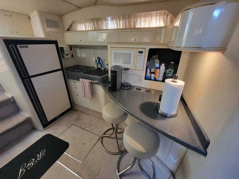 Slide: The Image of 1997 Sea Ray 400 Express Cruiser kitchen with modern appliances and seating area. - 14
