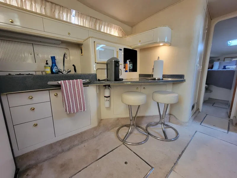 Slide: The Image of Interior of 1997 Sea Ray 400 Express Cruiser with modern kitchen and seating area. - 16