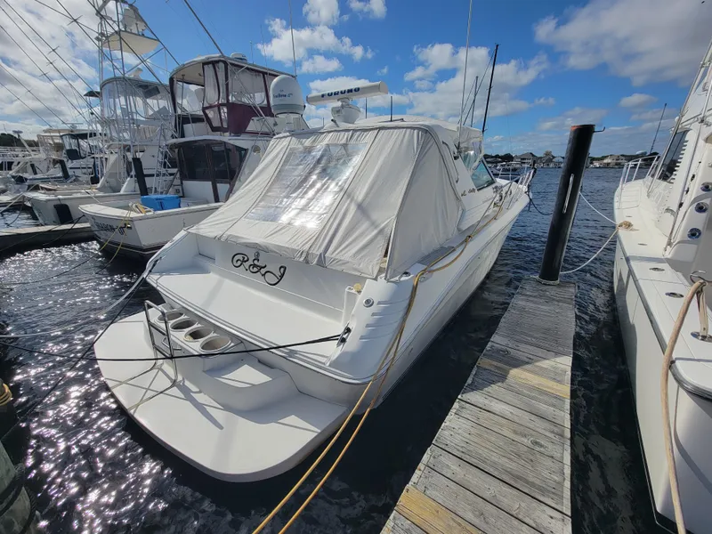 Slide: The Image of 1997 Sea Ray 400 Express Cruiser docked at marina under clear blue sky. - 5