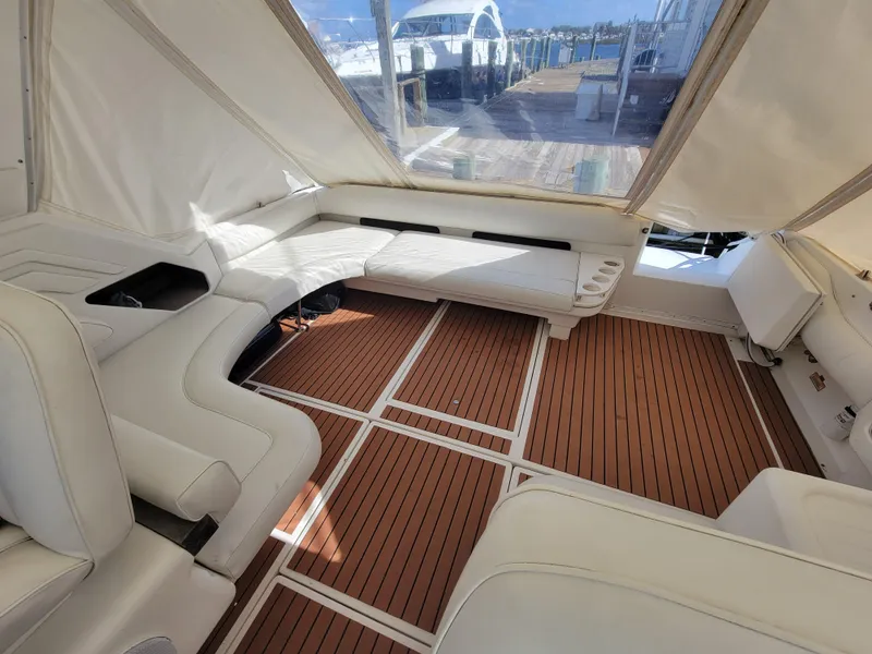 Slide: The Image of 1997 Sea Ray 400 Express Cruiser interior with white seating and wooden flooring. - 6