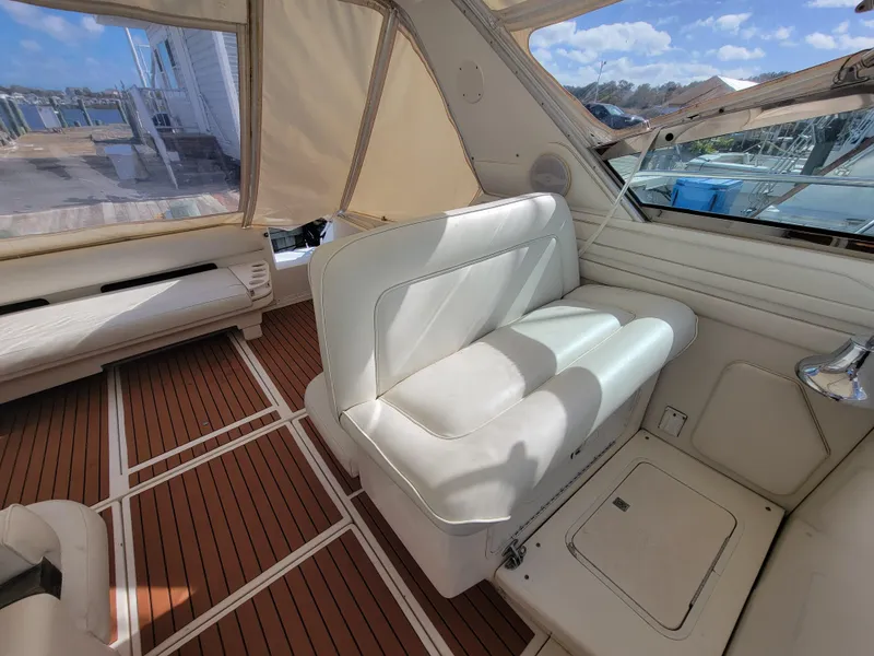Slide: The Image of 1997 Sea Ray 400 Express Cruiser interior with white seating and wood flooring. - 8