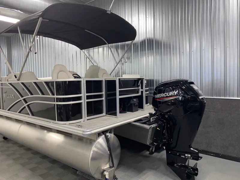 Slide: The Image of 2025 Sylvan Mirage 8520 Party Fish pontoon with Mercury 90HP engine in a metal-walled showroom. - 22