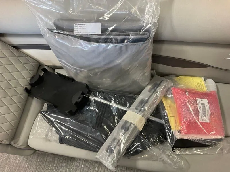 Slide: The Image of 2023 Bennington 21SSR boat accessories on seat, including packaged items and manuals. - 16