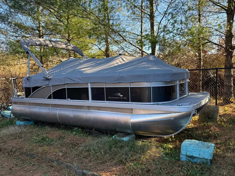 Slide: The Image of 2023 Bennington 21SSR pontoon boat covered and parked outdoors. - 17