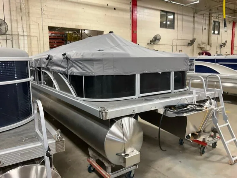 Slide: The Image of 2023 Bennington 21SSR pontoon boat with gray canopy in a warehouse setting. - 3