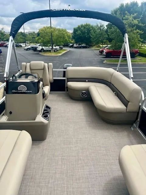 Slide: The Image of 2025 Sun Tracker Party Barge 16 DLX pontoon boat with beige seating and canopy. - 4
