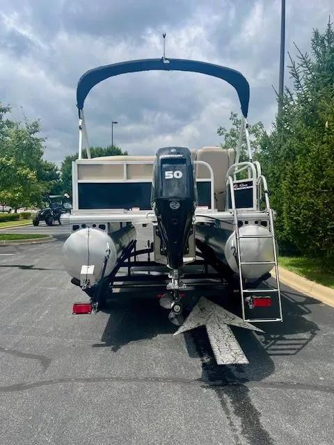 Slide: The Image of 2025 Sun Tracker Party Barge 16 DLX pontoon boat with 50 HP engine, parked outdoors. - 5