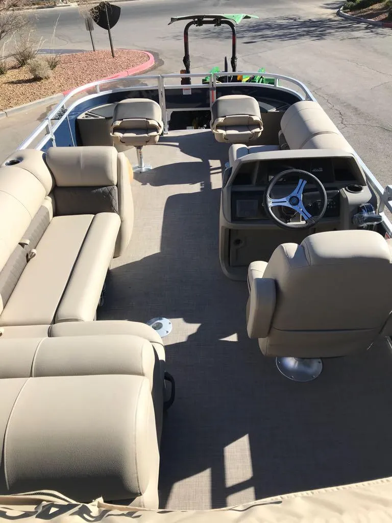 Slide: The Image of 2025 Sun Tracker Fishin' Barge 20 DLX interior with beige seating and steering console. - 13